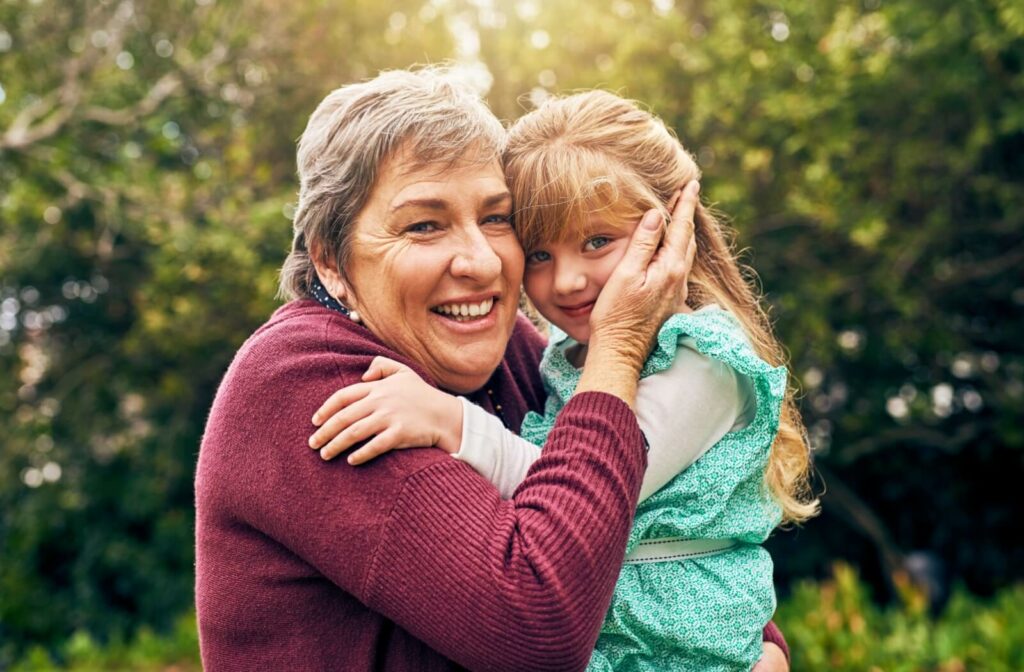 A young child hugging their grandparent while visiting them at an assisted living community
