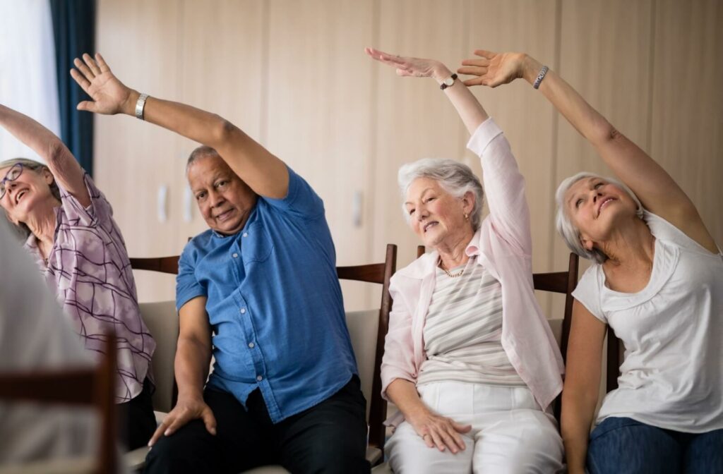 A group of seniors do indoor chair aerobics